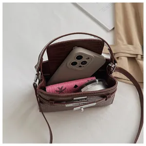 Detailed interior view showing capacity of brown crocodile embossed Kelly style handbag