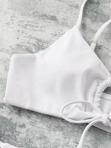 Detailed macro view showing the textured white ribbed fabric of a drawstring bikini top