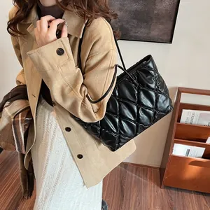 Fashionable black quilted puffer tote bag with large capacity for stylish winter commuting.