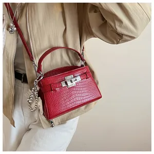 Close-up view of a vibrant red crocodile pattern handbag featuring a sleek silver lock