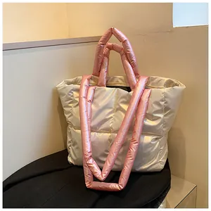 Detail view of large quilted puffer tote bag with long pink padded handles