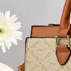 Detailed view of a stylish patterned commuter handbag with brown leather handle straps