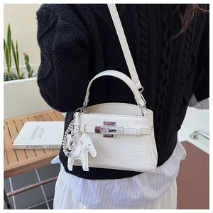 Detail of white crocodile pattern Kelly handbag with silver lock and horse charm.