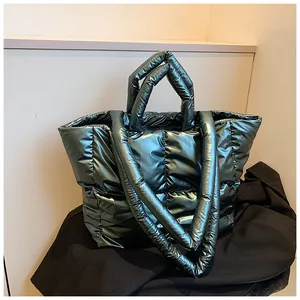 Large dark green metallic quilted puffer tote bag featuring dual handles and long shoulder strap