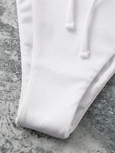Detailed macro shot showing the white ribbed fabric texture and drawstring on bikini bottom