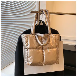 Elegant champagne gold metallic quilted puffer tote bag displayed on a lifestyle clothing rack