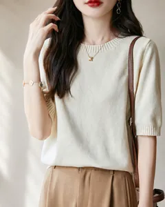 Dettaglio del morbido maglione a maniche corte in maglia di cotone bianco crema.