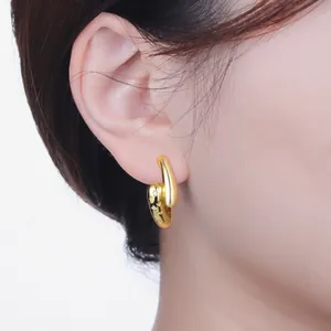 Elegant gold plated earring with star engraving displayed on an Asian model's ear.