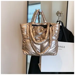 Stylish champagne gold metallic puffer tote bag hanging in a chic setting.