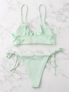 Mint green ribbed bikini set featuring triangle top and side-tie thong on marble