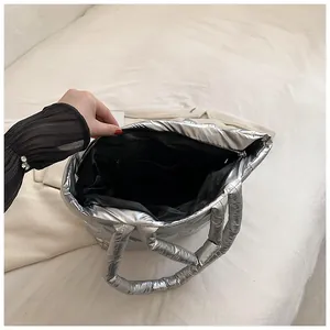 Detailed interior view of a silver metallic padded tote bag with black zipper closure.