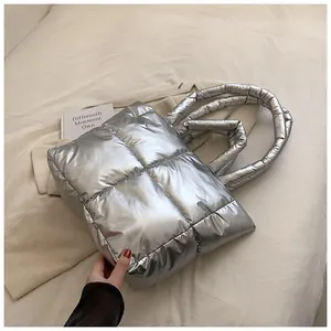 Silver metallic puffer tote bag with quilted design on white bedding