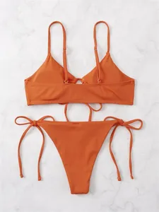 Detailed view of burnt orange ribbed bikini set with tie-side strings and adjustable straps