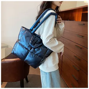 Detailed view of a large navy blue quilted puffer tote bag carried by an Asian model