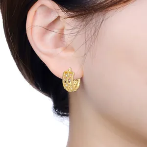 Detailed macro view of 18K gold plated hoop earrings with fleur-de-lis and CZ stones.