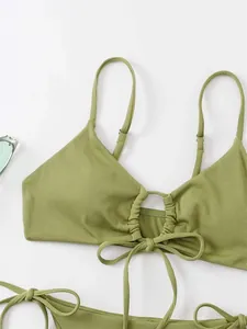 Detailed view of sage green ribbed bikini top with center ring and drawstring accents