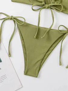 Detailed macro view of olive green ribbed fabric and tie-side string bikini bottom