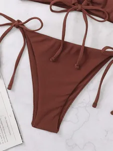 Detail shot of a sexy solid reddish-brown ribbed triangle bikini bottom with side ties