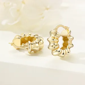 Close-up view of 18K gold plated wavy hoop earrings with high-shine polished finish