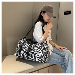 Close-up of large zebra print sports bag with multiple pockets shown on model lifestyle