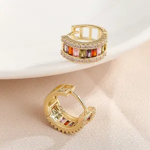 Detailed close-up of gold hoop earrings with vibrant multi-colored baguette cubic zirconia