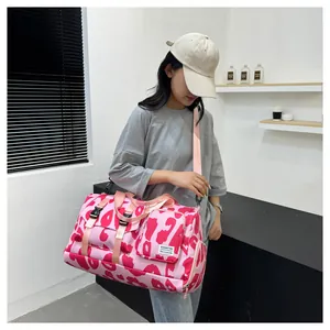 Asian model showing details of a large pink leopard print fitness travel bag