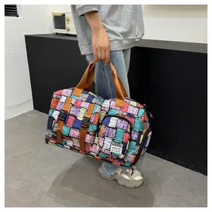 Detailed view of a large capacity colorful patterned sports travel bag held by hand