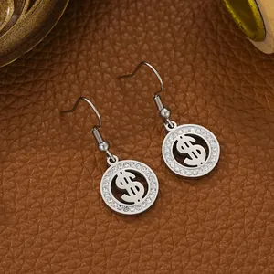 Detailed macro view of stainless steel dollar sign earrings with white crystal inlay