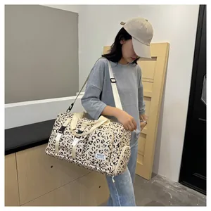 Woman carrying a large leopard print travel duffel bag for gym or short trips