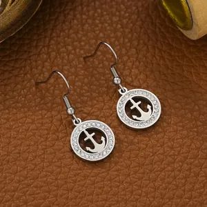 Detailed close-up of silver stainless steel anchor earrings with pavé rhinestones