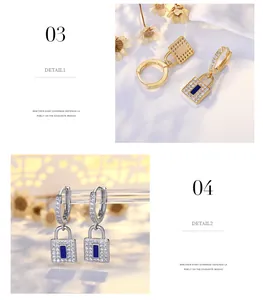 Close-up of gold and silver lock earrings with shimmering rhinestones and blue enamel