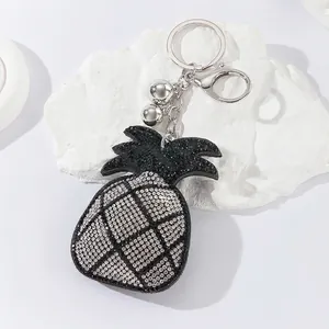 Close-up of cute pineapple keychain with sparkling rhinestones and silver hardware