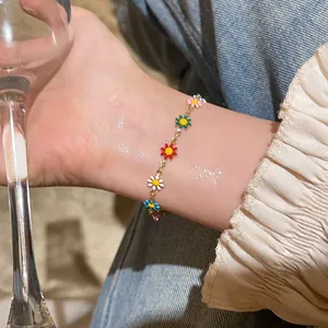 Colorful dopamine daisy flower charm bracelet on female wrist in warm lighting