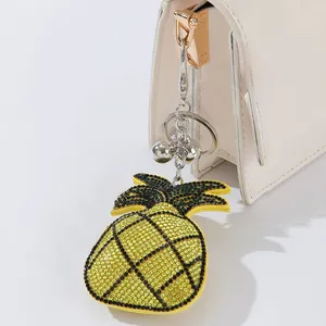 Detailed view of a sparkling rhinestone pineapple keychain used as a bag charm