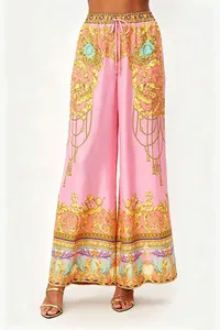Detailed view of women's ornate Baroque print wide-leg trousers in pink and gold.
