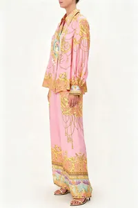 Elegant pink two-piece set featuring golden baroque print shirt and matching trousers.