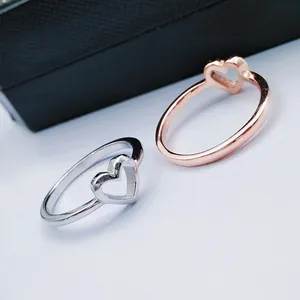 Detail view of heart-shaped minimalist rings in silver and rose gold finishes