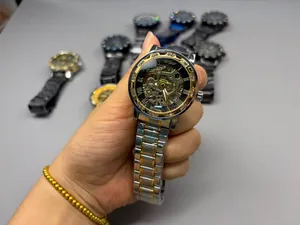 Detailed macro view of men's skeleton mechanical watch with rhinestone bezel and gold finish