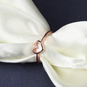 Elegant rose gold plated heart shaped ring presented on smooth white silk fabric.