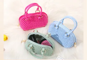 Detail view of three mini PVC jelly shell bags in pink, blue, and green on white fur.