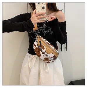 Vue détaillée d'un sac bandoulière tendance à motif vache avec sangle large.