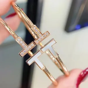 Primer plano de dos pulseras Double T de oro rosa con diamantes y nácar.