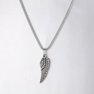Detailed macro shot of a stainless steel angel wing feather pendant on a chain.