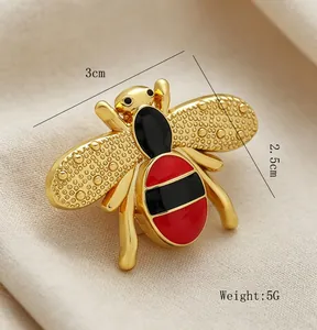 Detailed macro view of an elegant gold bee brooch with red enamel and 3cm size