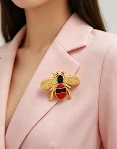 Close-up of a gold-toned bee brooch with red and black enamel on a pink blazer.