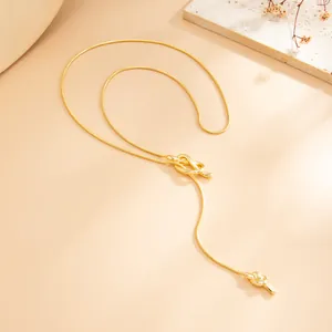 Detailed view of elegant gold-toned long tassel necklace with unique knot design