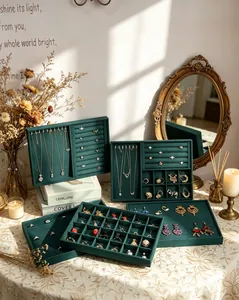 Detailed view of green velvet jewelry display trays showing organized necklaces and rings