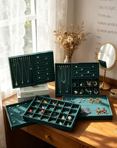 Elegant dark green velvet jewelry organizer trays for necklaces and rings on wooden desk