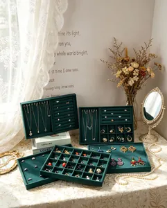 Elegant set of dark green velvet jewelry display trays in a cozy lifestyle setting