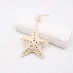 Détail d'un pendentif de sac étoile en cuir crème orné de clous en métal doré chic